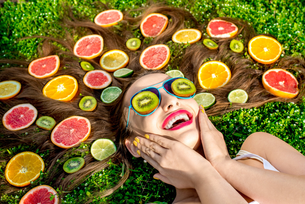 Woman lying down with various fruits in hair