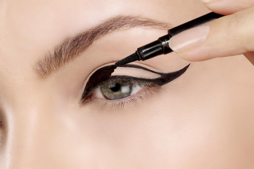 applying dark eyeliner to achieve dramatic look