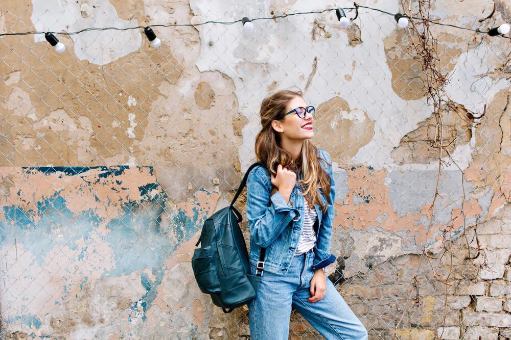 Happy woman in denim outfit and backpack 