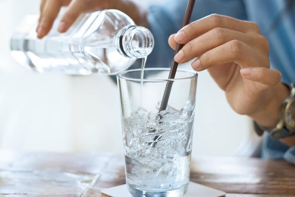 Stirring ice and pouring water into a glass