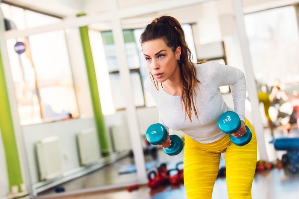 Woman working out with dumbbells at the gym