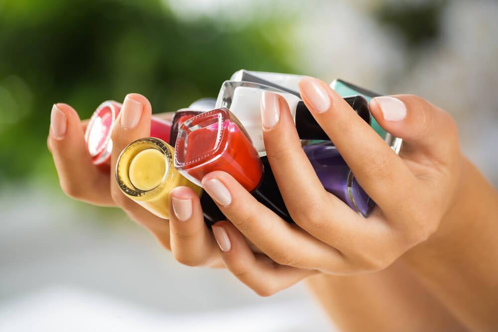 Hands holding nail polish bottles