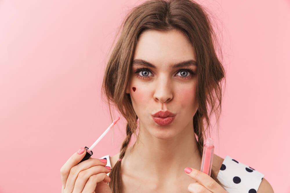 Woman applying lip gloss