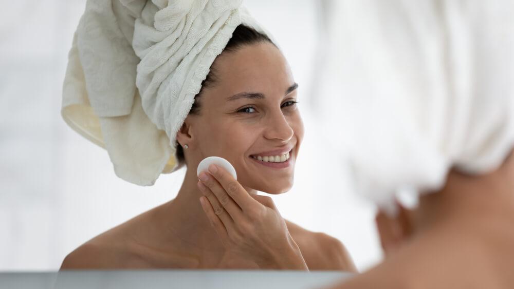 Woman cleansing face