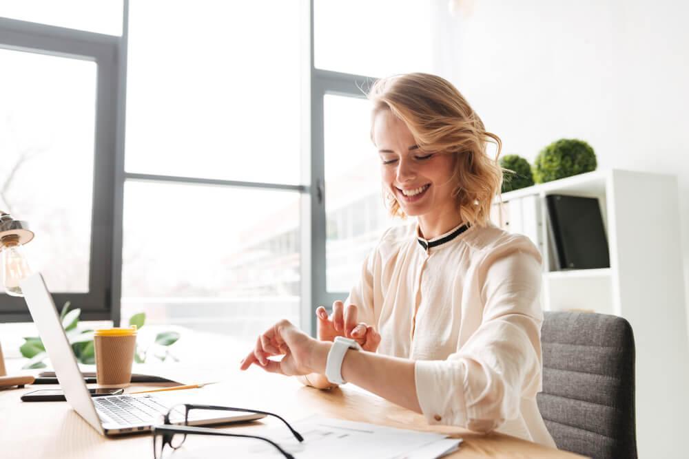 Woman in office looking at watch