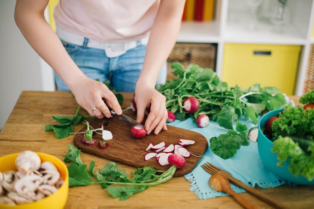 Woman chopping veg in kitchen