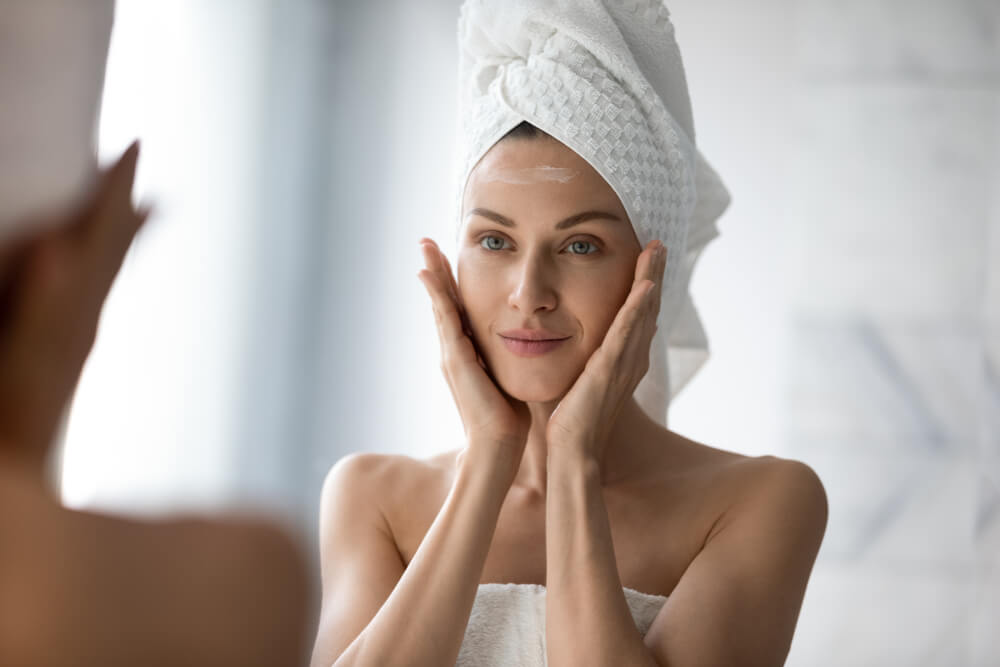 Woman looking at skin in mirror