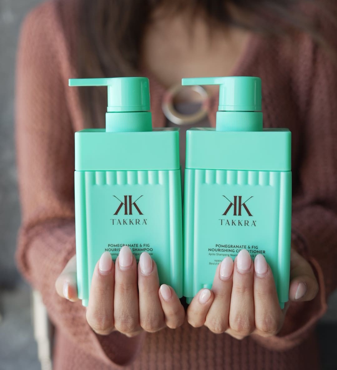 Woman holding Takkra shampoo and conditioner