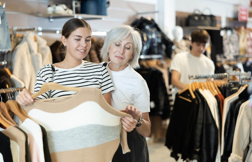 Women examining fabric of clothes in shop
